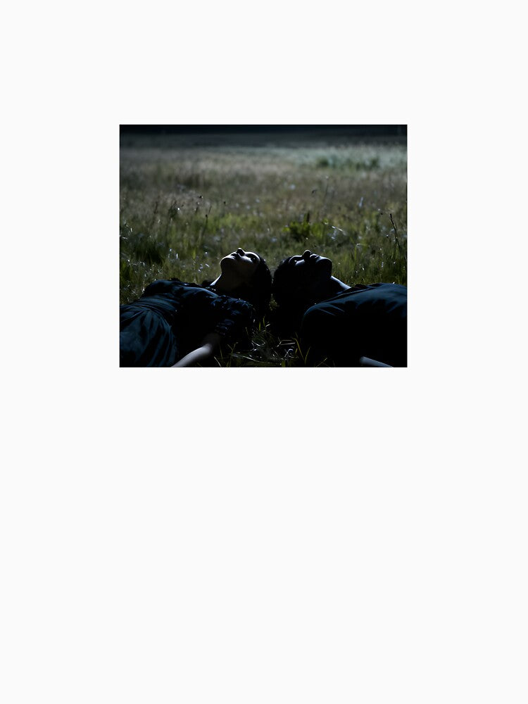 Young couple lying on the green field by Jimsartimages